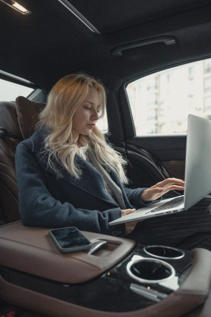 pexels-photo-5717642-1 Businesswoman working remotely on a laptop in the backseat of a luxury car. Stylish, modern, and focused.
